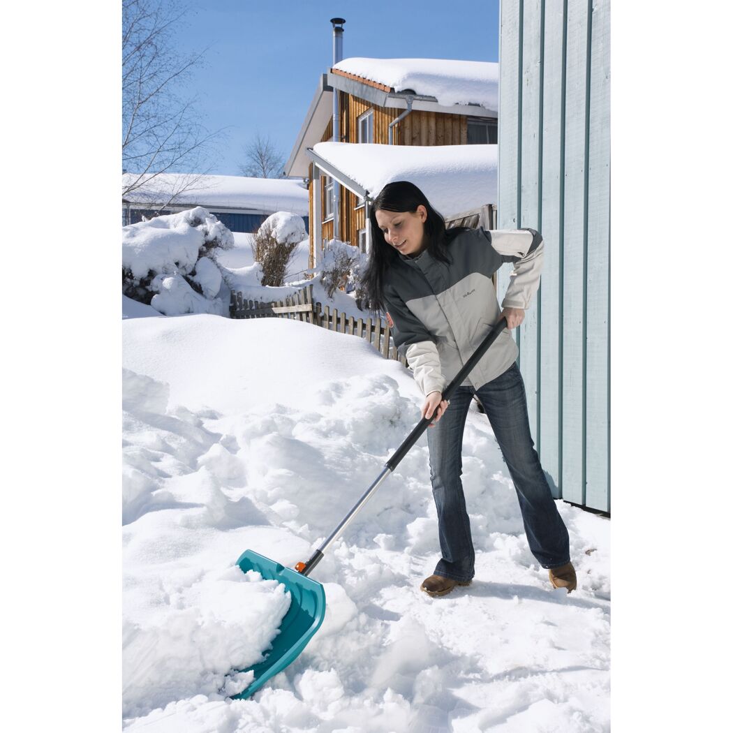 Person räumt Schnee mit Schneeschieber
