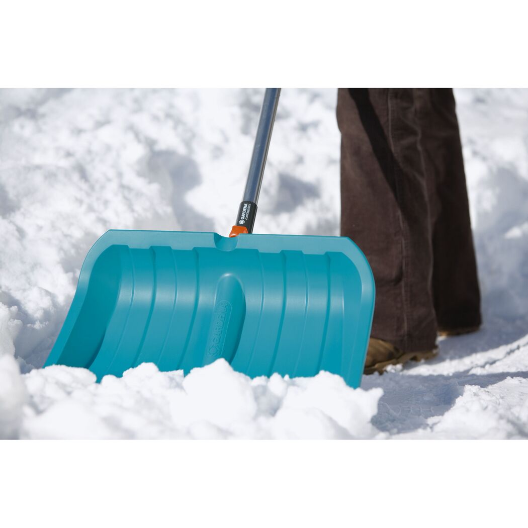 Person schiebt Schnee mit GARDENA Schneeschieber.
