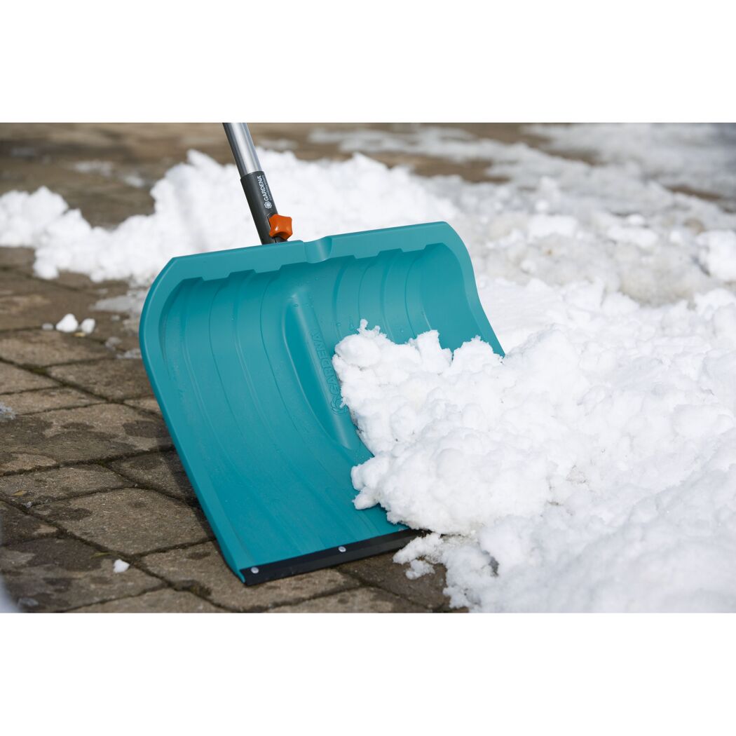 Schneeschieber räumt Schnee von Pflaster