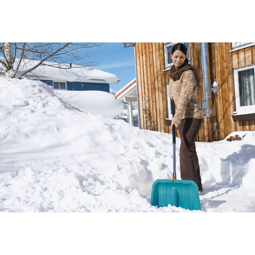 Person räumt Schnee mit Schneeschieber