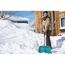 Person räumt Schnee mit Schneeschieber