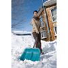 Person räumt Schnee mit Schneeschieber