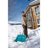Person räumt Schnee mit Schneeschieber