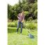Person rechen mit Laubbesen im Garten