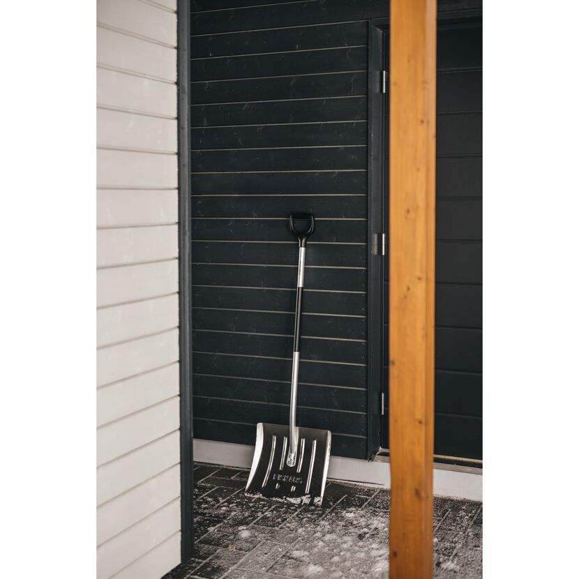 Schneeschaufel von Fiskars an einer Hauswand gelehnt