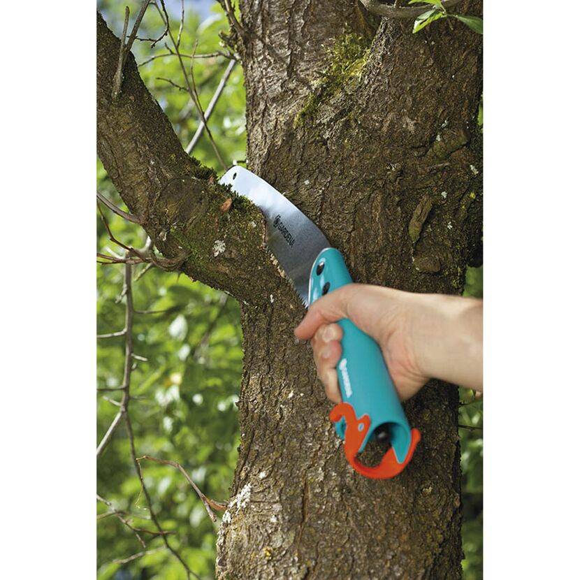 Person sägt mit Gartensäge einen Ast ab.
