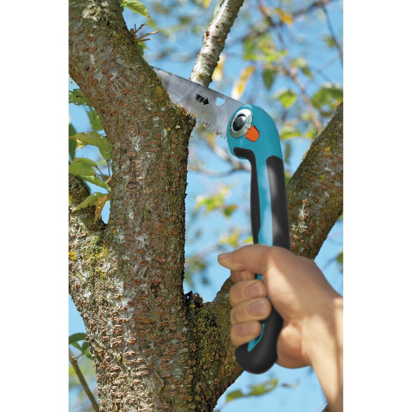 Person sägt mit Gartenklappsäge einen Ast ab