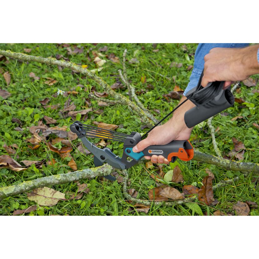 Person verwendet eine Gartenschere zum Schneiden eines Astes.