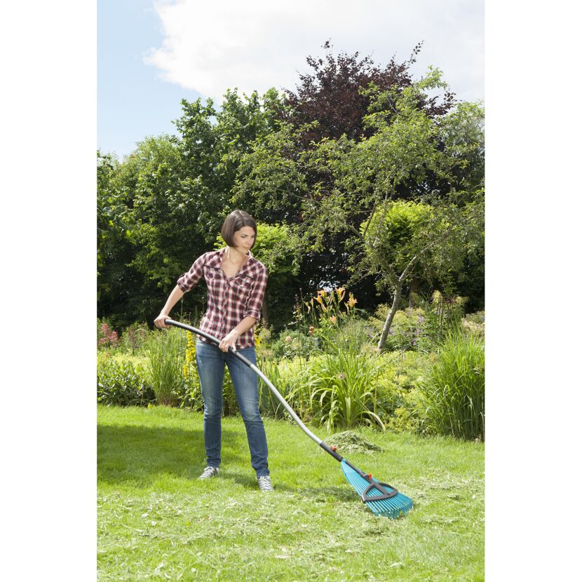 Person rechen mit Laubrechen im Garten