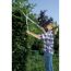 Person schneidet Hecke mit Teleskopheckenschere