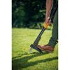 Person entfernt Löwenzahn mit dem Fiskars Xact Unkrautstecher.