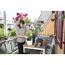 Person schneidet Blumen auf einem Balkon mit Gartenschere.