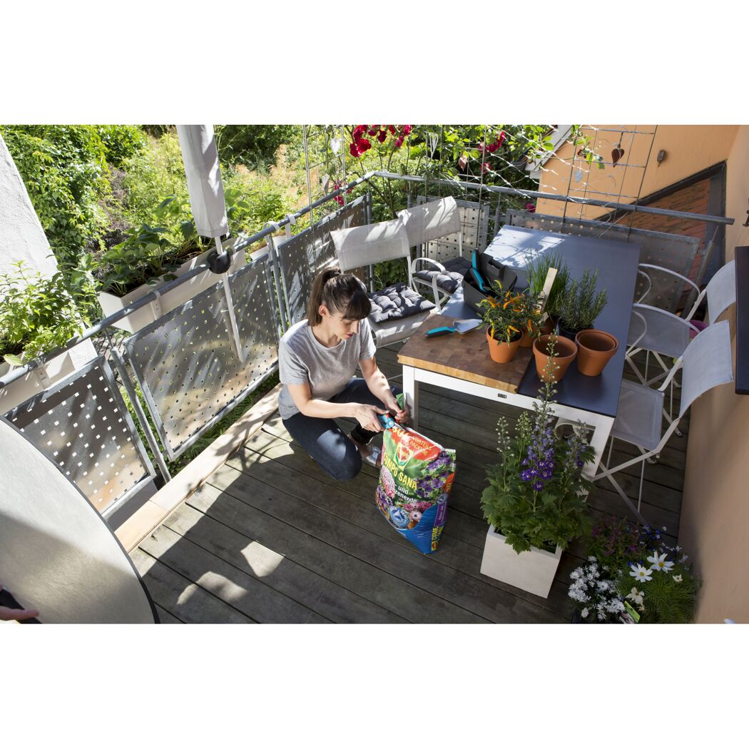 Person öffnet COMPO SANA Balkon- und Kübelpflanzenerde