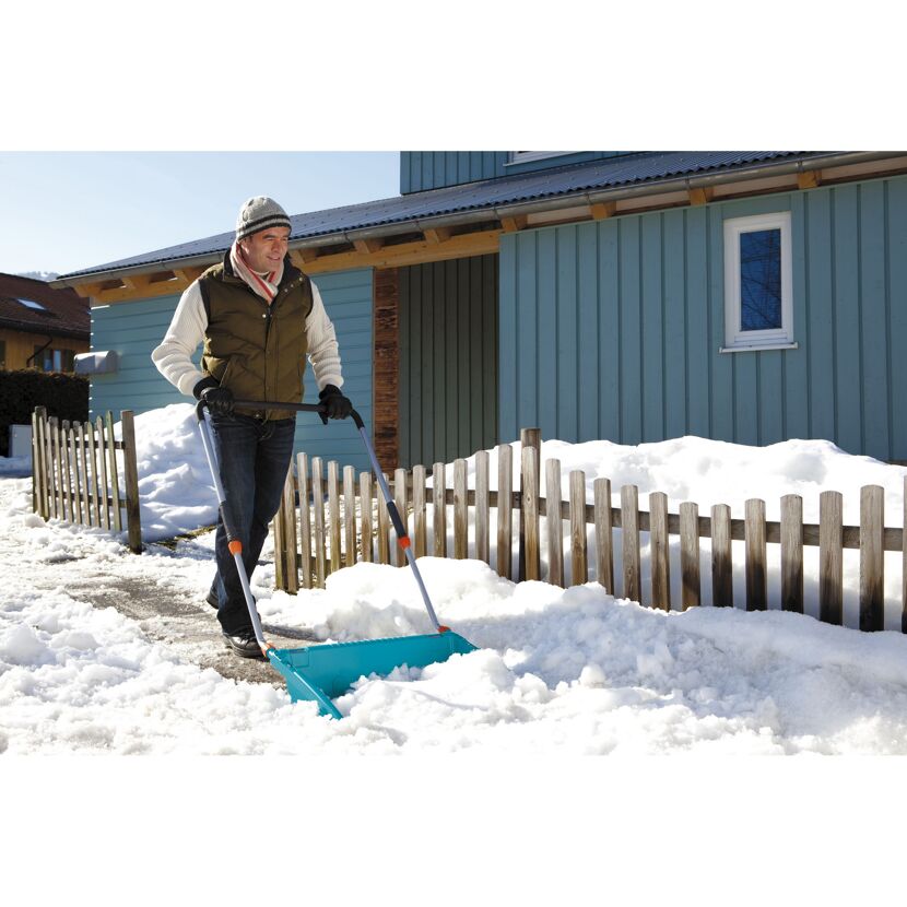 Person räumt Schnee mit Schneeschieber