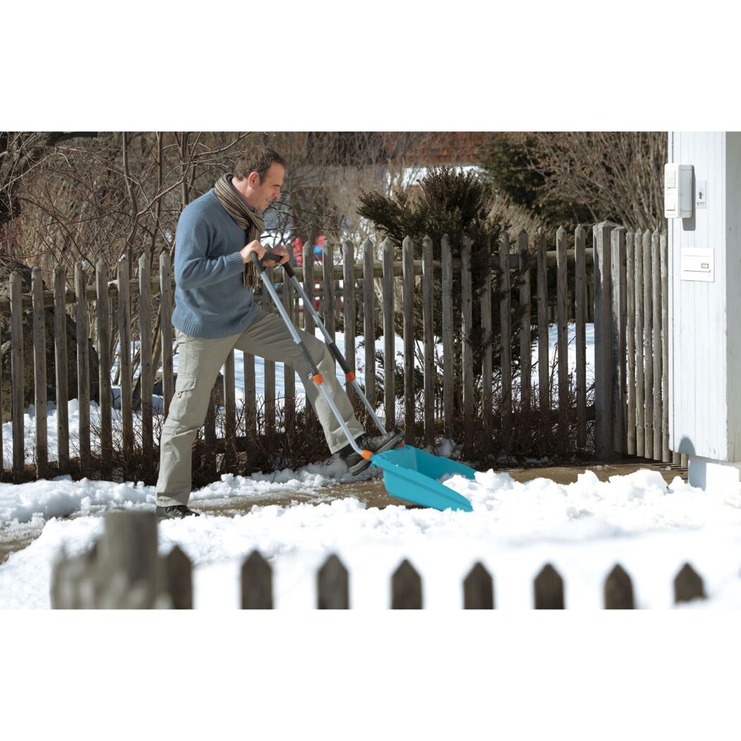 Person räumt Schnee mit Schneeschieber