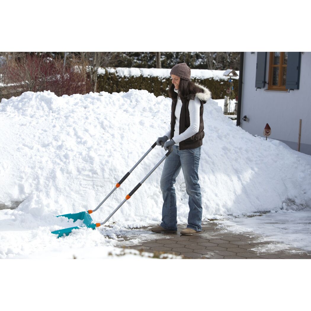 Person räumt Schnee mit Schneeschieber