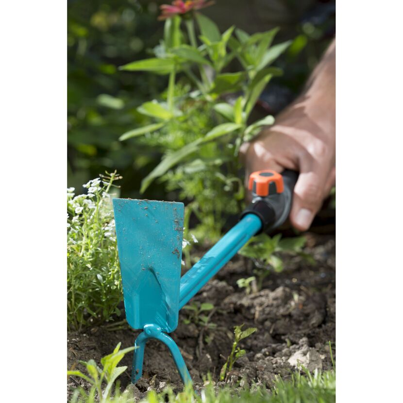 Person jätet mit Kleinhacke im Garten
