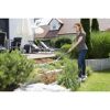 Person jätet mit einem Handrechen Unkraut im Garten.