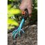 Hand harkt mit Blumenkralle den Boden