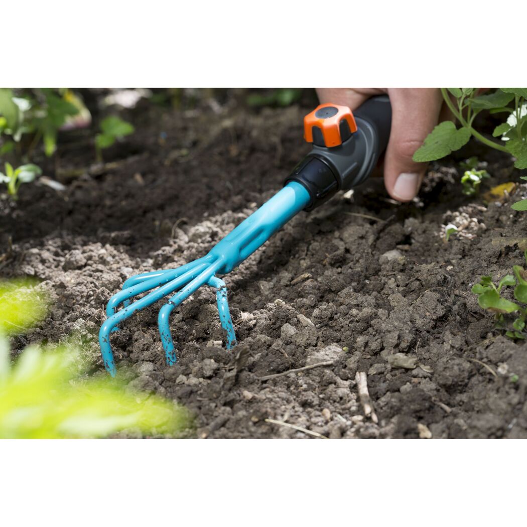 Hand verwendet Blumenkralle im Garten.