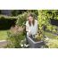 Person lockert Erde mit Blumenkralle