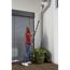 Person reinigt Hauswand mit Winkelbesen.