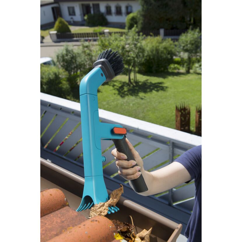 Person reinigt Dachrinne mit Dachrinnenreiniger.