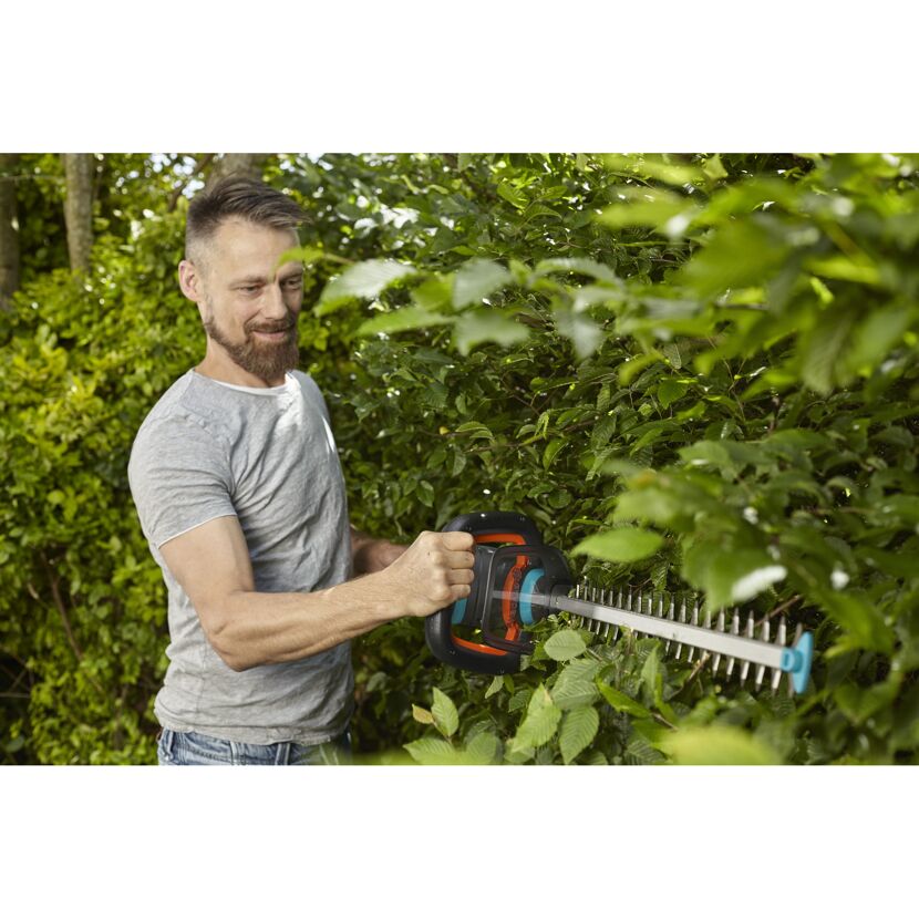 Person schneidet eine Hecke mit einer Akku-Heckenschere.