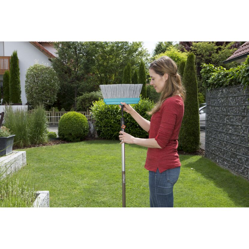 Person montiert einen Terrassenbesen.