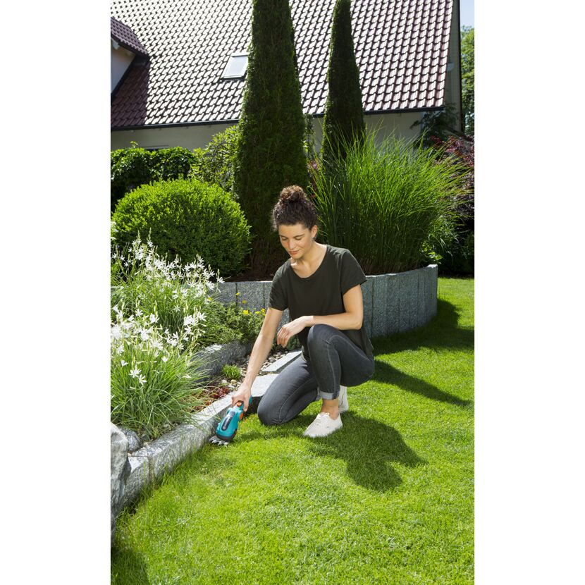Person schneidet Rasenkante mit Akku-Gras- und Strauchschere