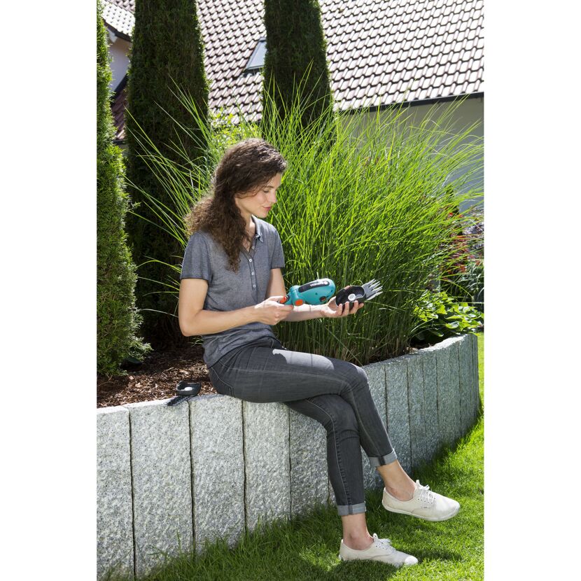 Person betrachtet einen Akku-Grasschere von Gardena.