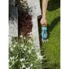 Person schneidet Rasen mit GARDENA Akku-Grasschere.