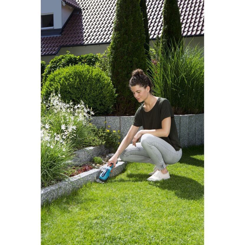Person schneidet Rasen mit Akku-Grasschere ComfortCut.