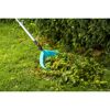 Person sammelt Gartenabfälle mit Schaufelrechen.