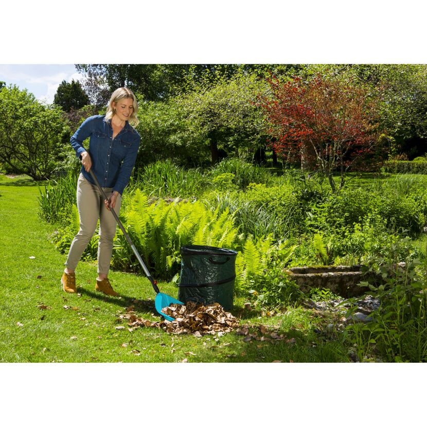 Person verwendet Combisystem-Schaufelrechen im Garten.