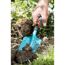 Hand benutzt einen Handgrubber im Garten.