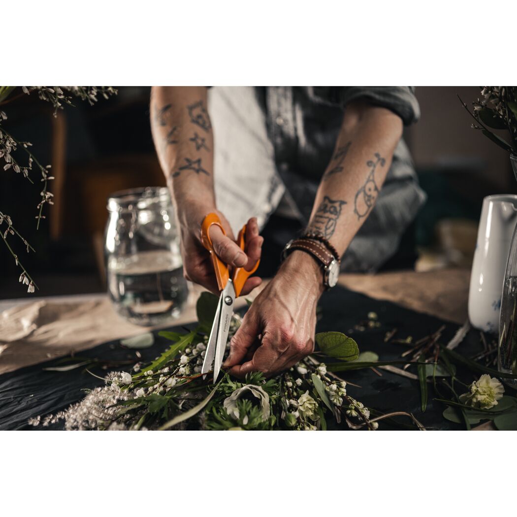 Person schneidet Blumen mit einer Fiskars Schere