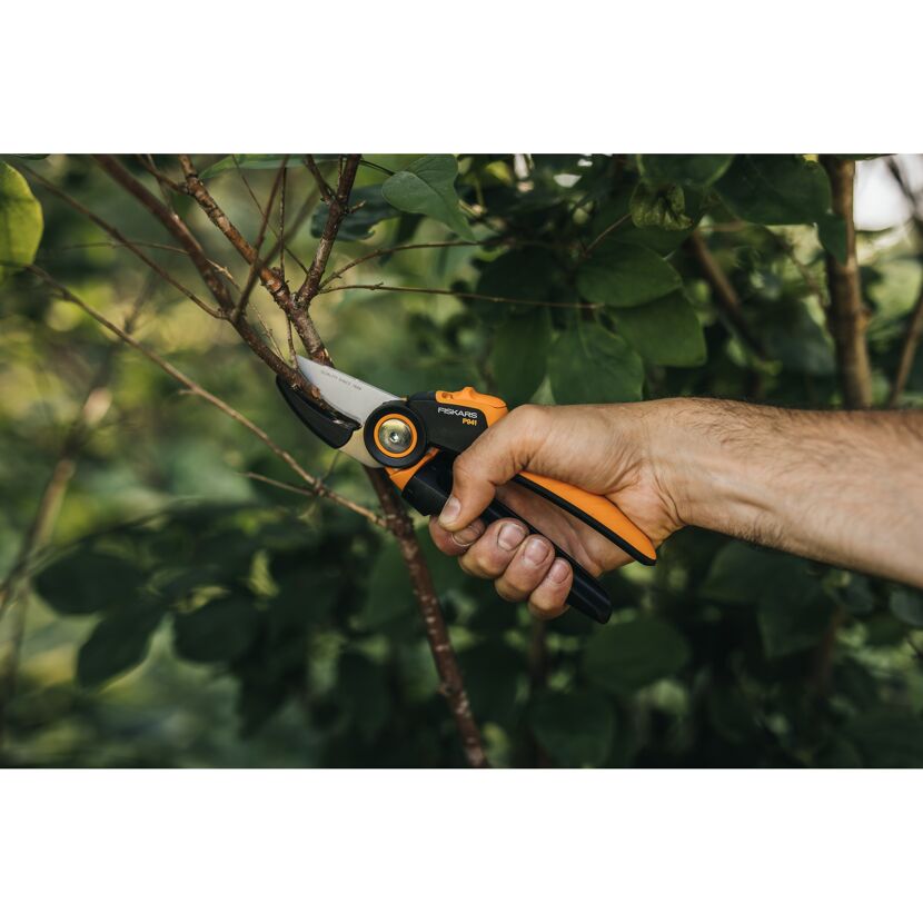 Person schneidet einen Ast mit der Fiskars Gartenschere P941.