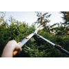 Person schneidet Hecke mit Teleskopheckenschere