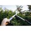Person schneidet Hecke mit Teleskopheckenschere
