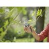 Person schneidet eine Pflanze mit Gartenschere