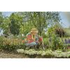 Person jätet mit Unkrautstecher im Garten Unkraut