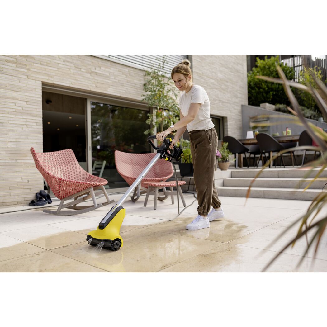 Person reinigt Terrasse mit Kärcher PCL 3-18 Terrassenreiniger.