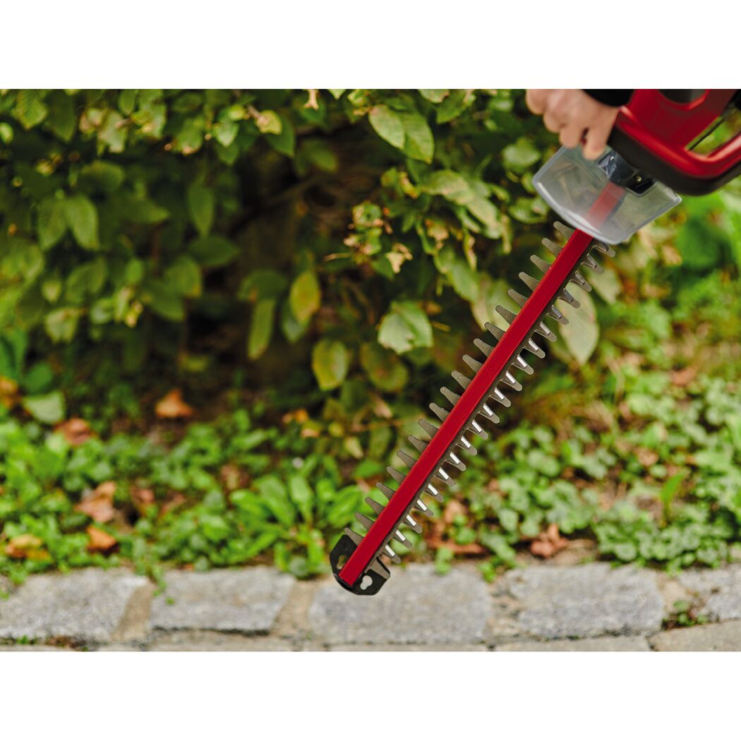 Person verwendet eine Heckenschere