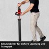 Person steckt Akku-Heckenschere in Schutzköcher für Lagerung.