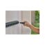 Person montiert den GARDENA Stielhalter Flex an eine Holzwand.