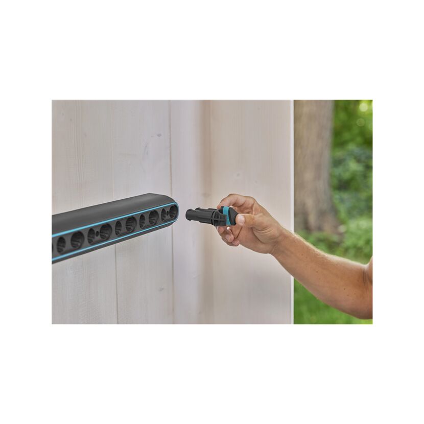 Person montiert den GARDENA Stielhalter Flex an eine Holzwand.