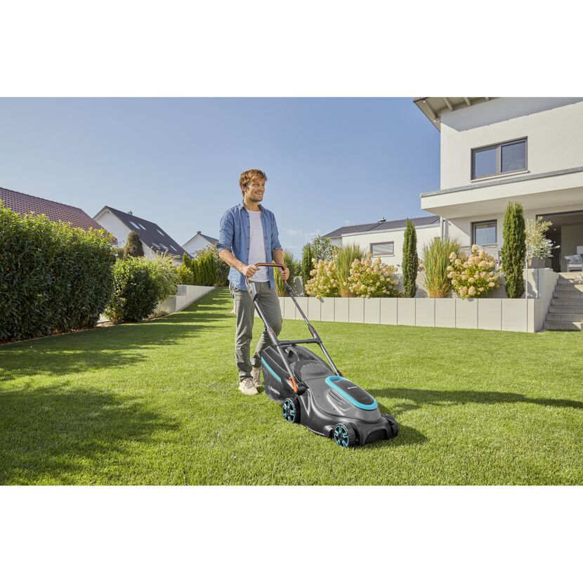 Person mäht Rasen mit Akku-Rasenmäher PowerMax