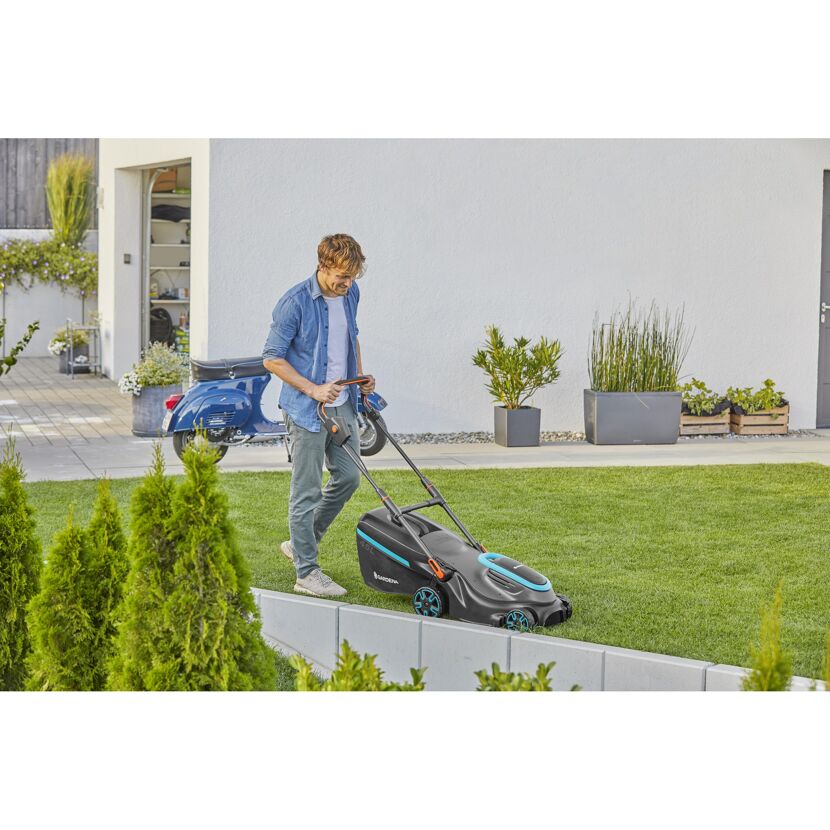 Person mäht Rasen mit GARDENA Akku-Rasenmäher.