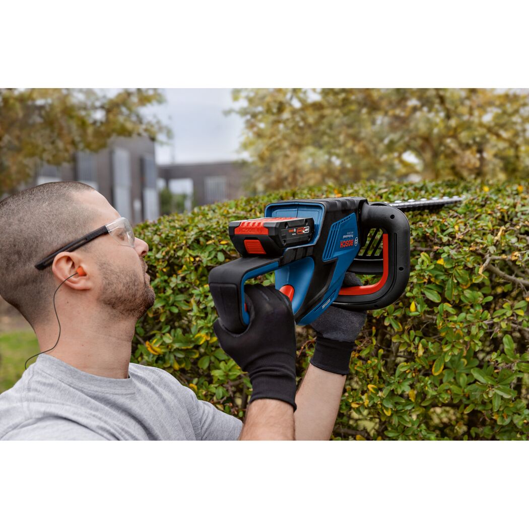 Person schneidet Hecke mit Akku-Heckenschere